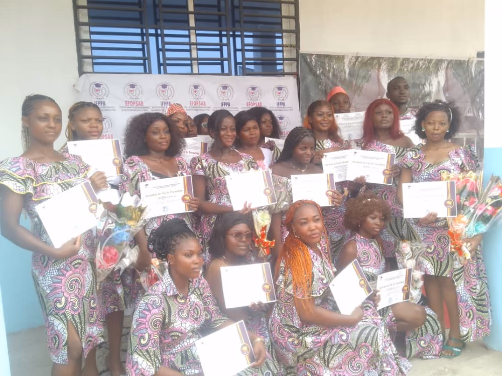 Les diplômées présentent leur attestation encadrée, bouquets à la main, devant le kakémono aux logos IFPPB et EFOPSAB.